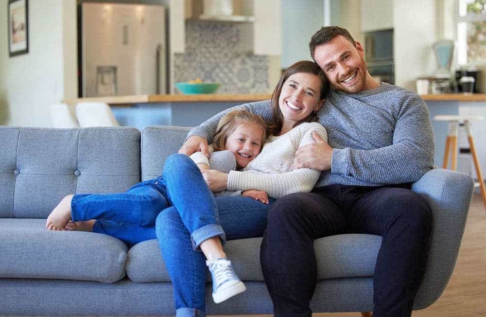 A Family sitting comfortable on a couch